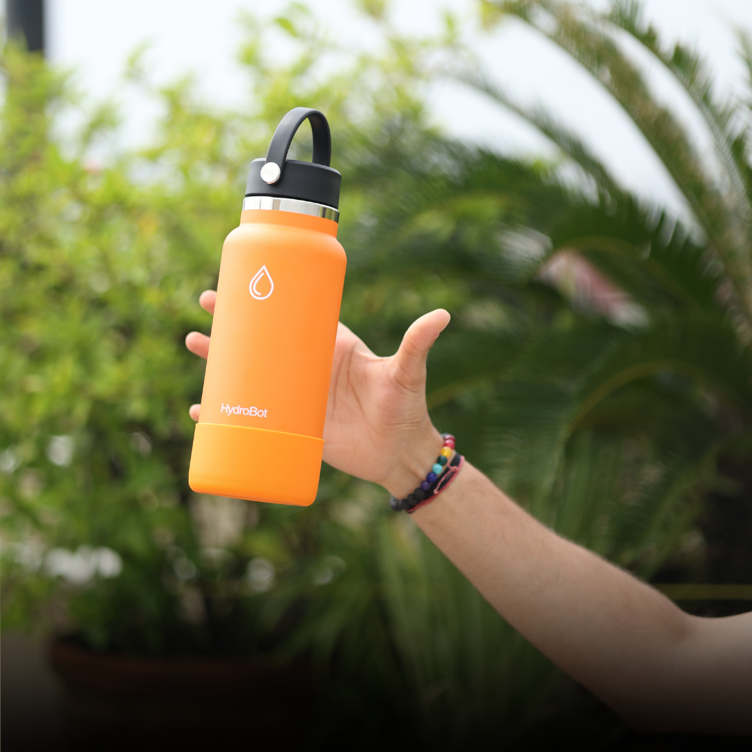 Hand pouring coffee from a black carafe into a glass.