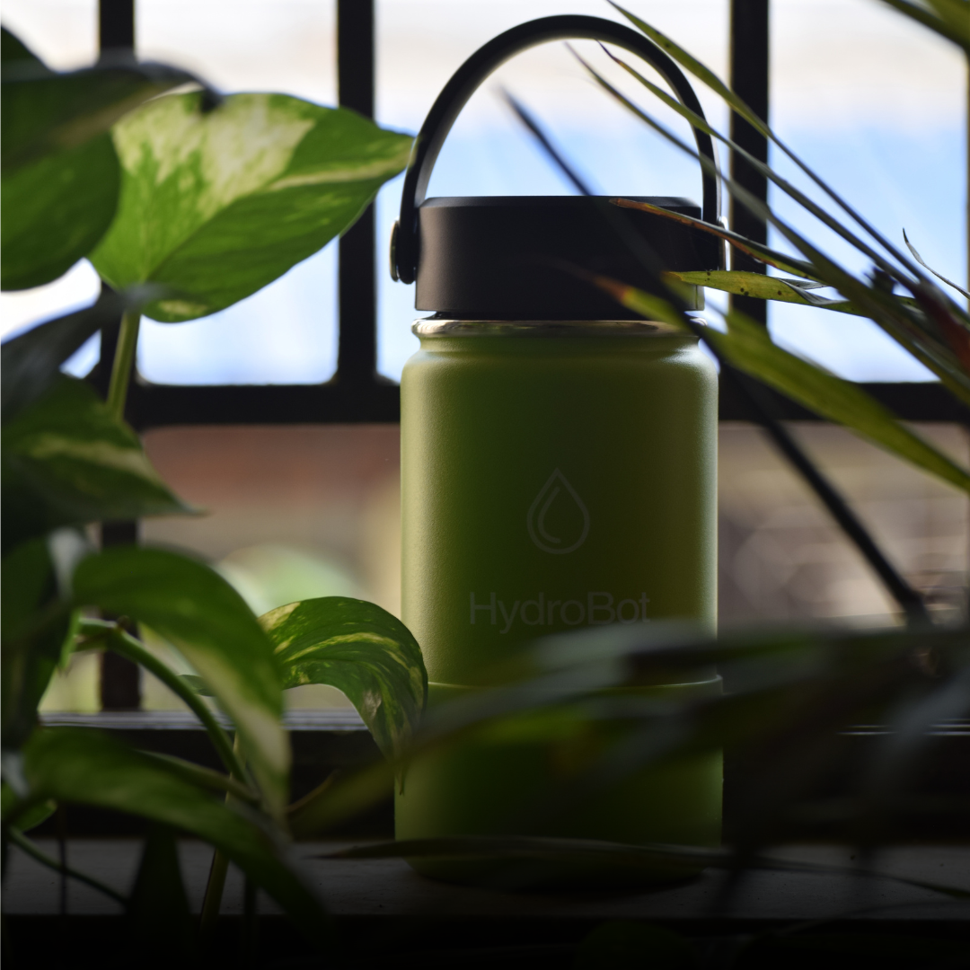 Hand pouring coffee from a black carafe into a glass.