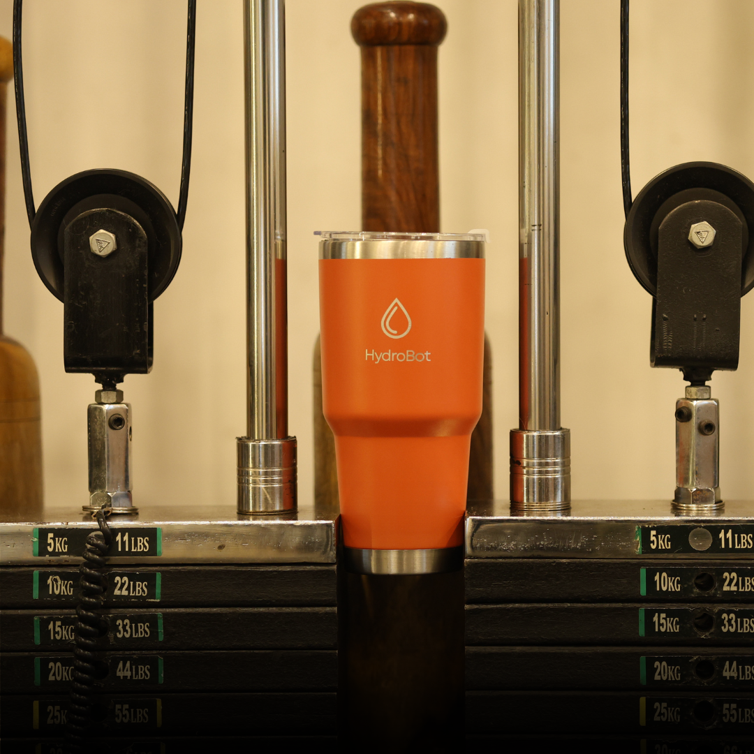 Hand pouring coffee from a black carafe into a glass.