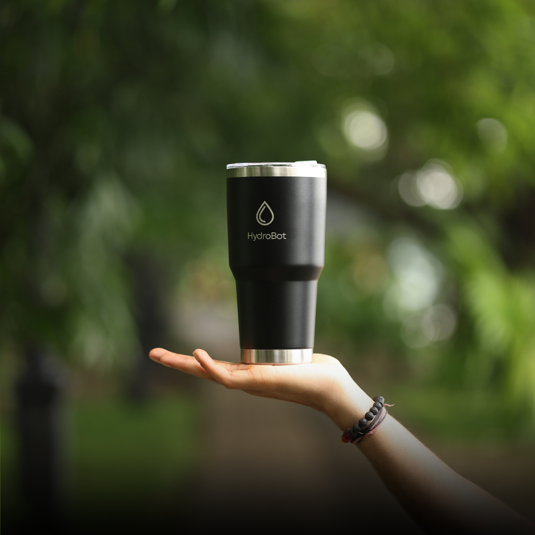 Sleek black French press with wooden handle on a kitchen countertop.