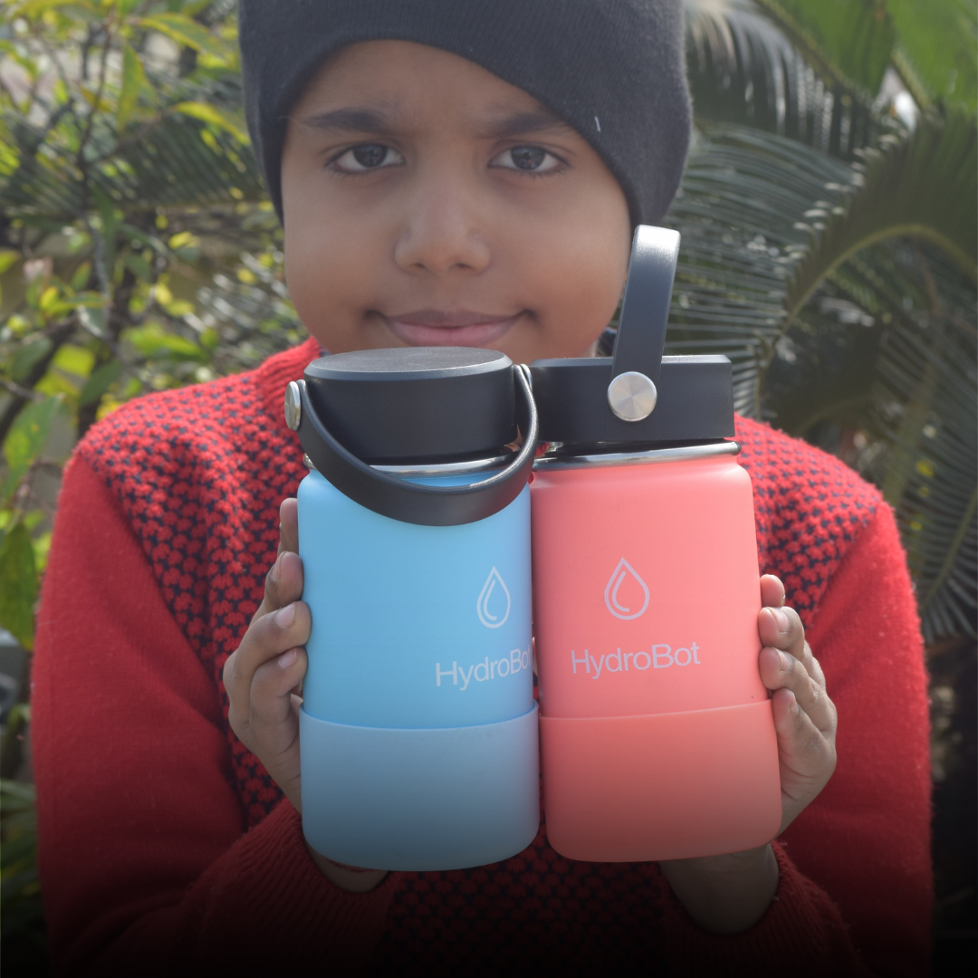Close-up of a coffee filter and a black kettle on a table with people in the background.