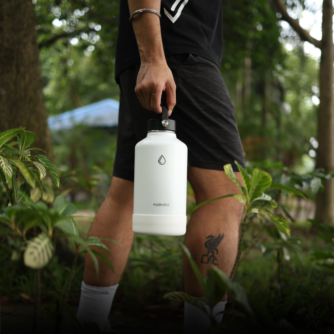 Hand pouring coffee from a black carafe into a glass.